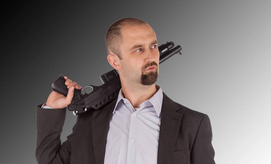 Mafia man is holding a shotgun, isolated on white